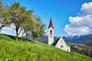 Die Pfarrkirche Maria Himmelfahr in Feldthurns inmitten der Berglandschaft in Südtirol