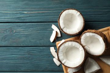 Board with coconut on wooden background, space for text