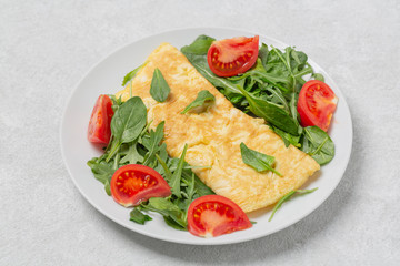 Omelette with tomatoes arugula and spinach. Healthy breakfast.