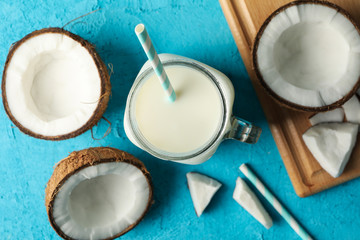 Coconut and milk on blue background, top view