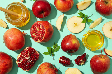 Flat lay with apple, honey and pomegranate on mint background