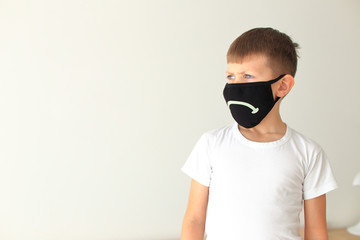 Boy puts on a quarantine respiratory mask at home