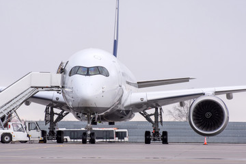 View of on a long-range passenger aircraft at airport with a ramp in the parking lot.