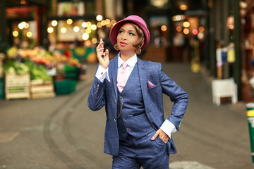 a portrait of a young woman dressed in a tweed suit smoking a cigarette