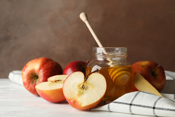 Apples and honey against brown background, close up