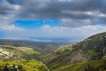 Fototapeta na wymiar Panoramic view of beautiful green calming landscape of Mediterranean valley below clean blue cloudy sky.