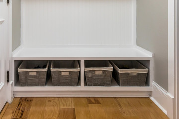 a row shelf of storage baskets for home organization inside the mudroom of a new construction house