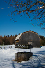 Vieille grange avec puit d'eau en campagne canadienne au Québec en hiver