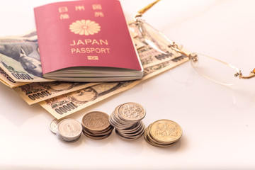 Japanese coins and banknotes and passport on white table