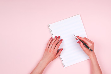 Obraz premium Woman hands with music book on light pink background