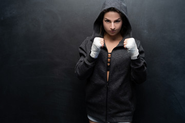 Female bodybuilder wearing hand gloves for exercise on grey background with lots of copyspace