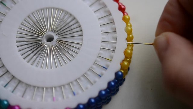 A seamstress woman removes a pin
