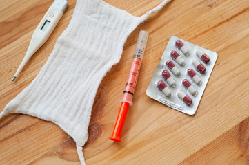 Medical concept. Drugs, face mask, thermometer and syringe on desk. Copy space. Top view