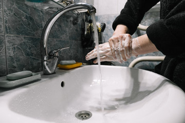 A man washes his hands with soap over the sink. Hand disinfection during the coronavirus pandemic. Hygienic procedure. Virus, infection, epidemic, pandemic, infection.