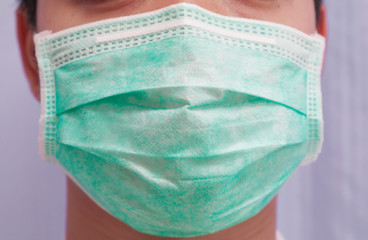 Man wearing surgical mask for coronavirus prevention, closeup of face not seen eye, selective focus, protection outbreak concept