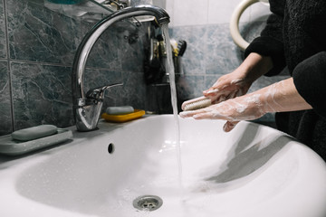 A man washes his hands with soap over the sink. Hand disinfection during the coronavirus pandemic. Hygienic procedure. Virus, infection, epidemic, pandemic, infection.