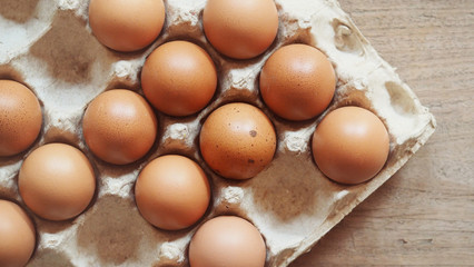 Selective focus, organic brown chicken eggs in carton on rustic wooden table backgrounds for natural healthy food concepts