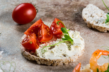 Puffed rice cakes with shrimps and avocado on board. Seafood snack. Crispbread, bread crusts. diet food concept. Basil. Healthy food. Healthy breakfast. Cherry tomatoes. Organic food