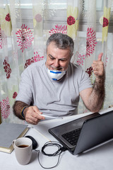 Adult man working at home with protective mask