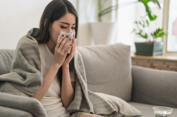 Fototapeta premium Daily life or health problem concept : Young Asian woman caught a cold and have a running nose or fever have to rest at her home and absent from her job.