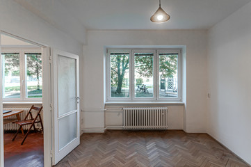 Empty room with white walls, wooden floor and window 