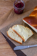 Sweet roll called challah with butter. On woodden board.