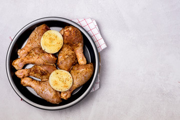 Spicy Glazed Chicken Legs on Black Plate Ready to Cook Homemade Food Concept for a Tasty and Healthy Dish. Gray Background Top View
