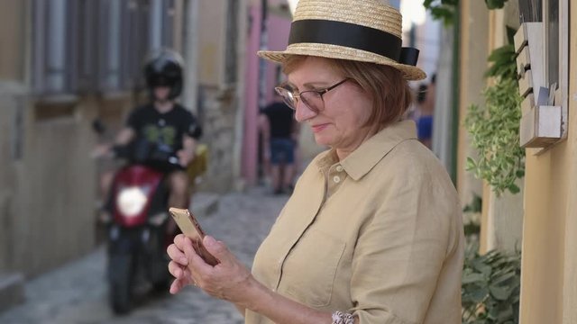 Mature woman with mobile in the town street