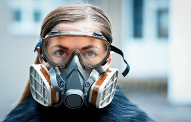 Young woman wearing full face respirator protective mask and goggles, extreme coronavirus protection concept - obrazy, fototapety, plakaty
