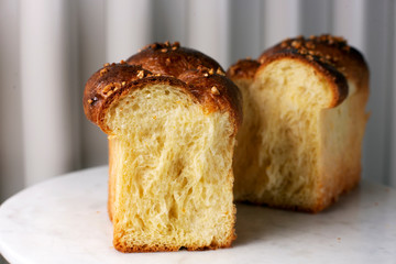brioche, cut in half, on a light background