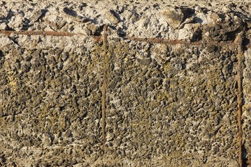 gray stone texture from old shabby concrete wall with brown rusty iron fittings