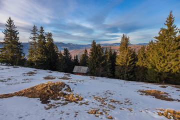Sunset spring Carpathian mountains landscape with snow-covered ridge.