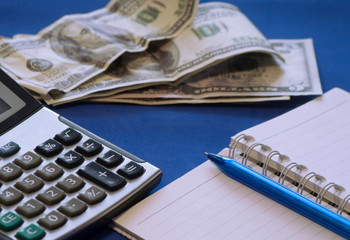 the workspace on the table, where there is a calculator and banknotes for calculating savings, finances, accounting expenses of the accounting department of an enterprise or bank