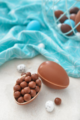 Tasty chocolate Easter eggs with candies on table