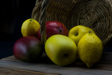mangoes and yellow apples with a basket of natural cane