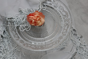One orange clove on a glass plate with grey scarf