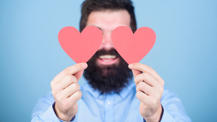 Having eyes only for his love. Bearded man covering eyes with red hearts. Sexy valentine man holding love cards. Hipster with small hearts. Happy valentines day. Expressing his love