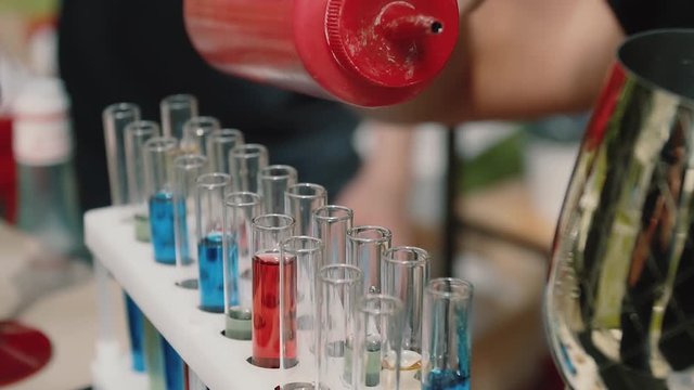 red blue alcoholic cocktails in transparent test tubes pours the bartender on a light background, pour cocktail bar. fon