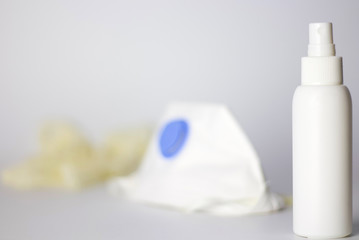 Coronavirus prevention items N95 mask,surgical gloves and 80 degree alcohol for hand disinfectant corona virus protection. Focus on hand disinfectant on white background.