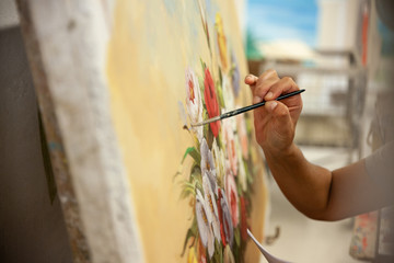 woman painting frescoes with brush close-up