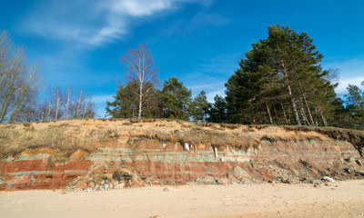 Fototapeta na wymiar seascape with blue sky and calm sea, steep bank in the background