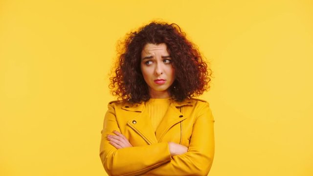 offended curly girl standing with crossed arms isolated on blue