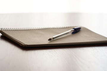 notebook and pen on wooden table