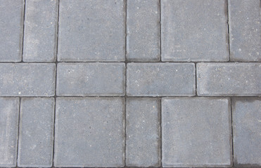 Gray texture of paving stones. Close-up of stone tiles for sidewalks