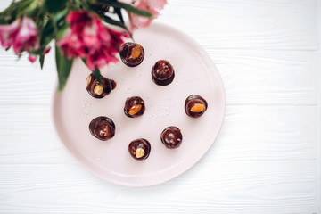 Homemade chocolate candy with nuts on a plate. Flat lay