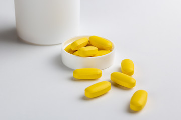 yellow pills and bottle isolated on white background