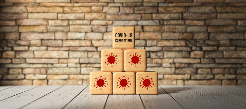 cubes with message COVID-19 and virus symbols in front of brick wall