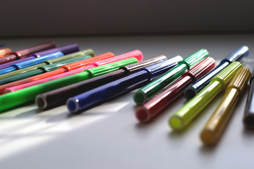 Colorful markers lie on the table under the window