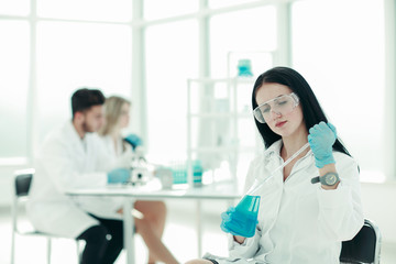 close up.woman scientist takes a sample of the liquid .