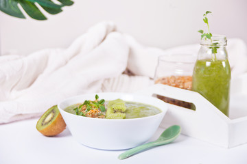 Fresh blended green smoothie bowl with muesli and chia seeds. Health and detox concept.